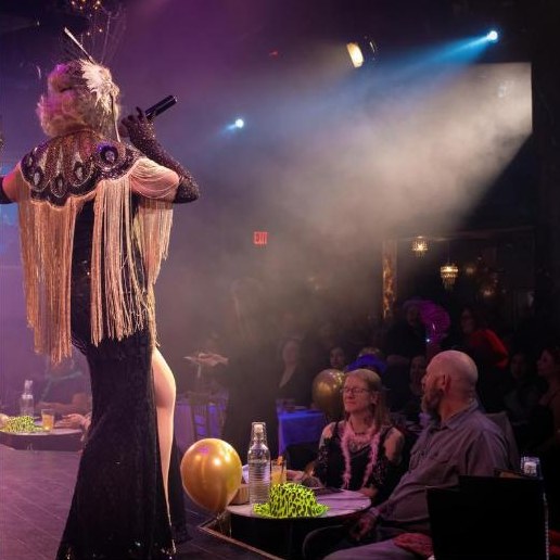 Performer in gold fringe on stage